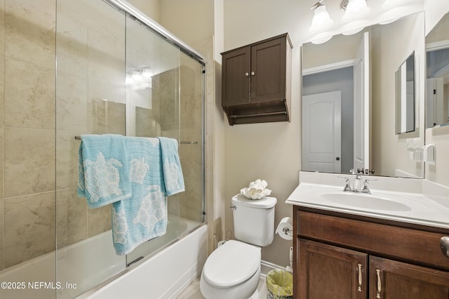bathroom featuring vanity, bath / shower combo with glass door, and toilet