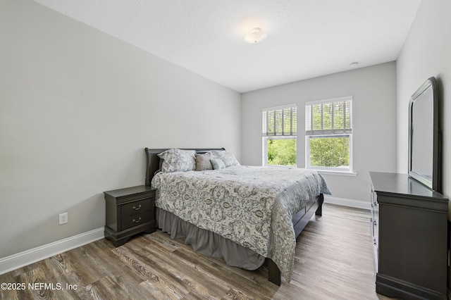 bedroom featuring baseboards and wood finished floors