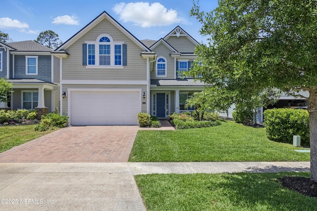 view of front of home featuring an attached garage, decorative driveway, and a front lawn