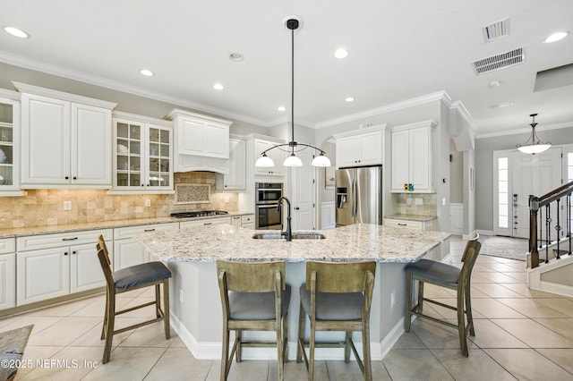 kitchen with a sink, tasteful backsplash, stainless steel appliances, and light tile patterned flooring