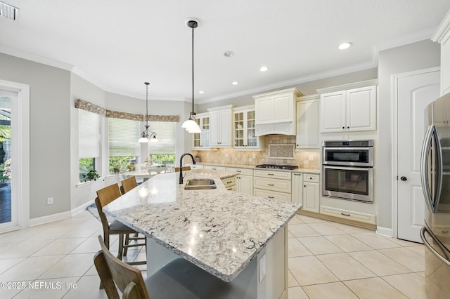 kitchen with a sink, light tile patterned floors, a kitchen bar, and stainless steel appliances