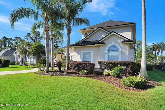 view of front of property with stucco siding and a front yard