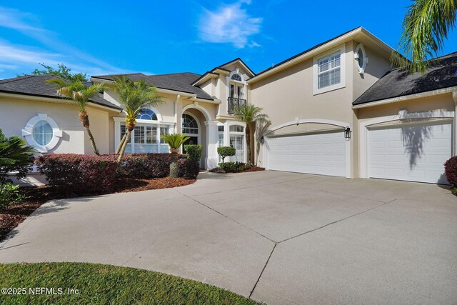 mediterranean / spanish-style home with an attached garage, stucco siding, and concrete driveway