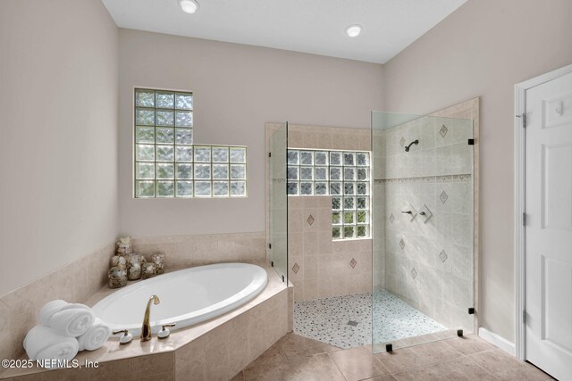 bathroom featuring a walk in shower, tile patterned flooring, and a garden tub
