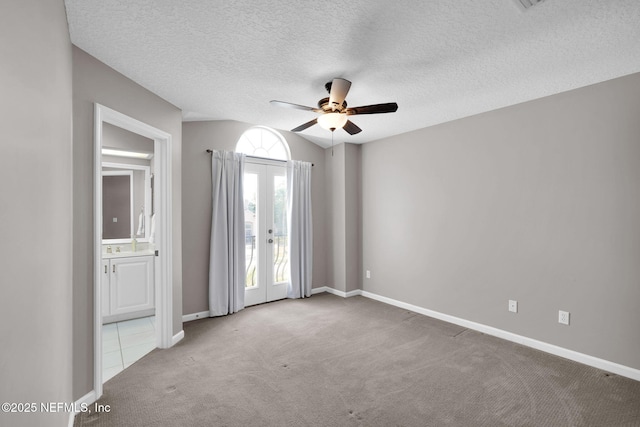 spare room with carpet floors, baseboards, ceiling fan, a textured ceiling, and french doors
