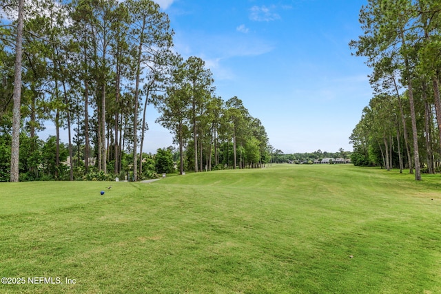 view of community with a yard and view of golf course