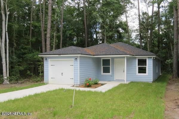view of front of property featuring a front yard, driveway, and a garage