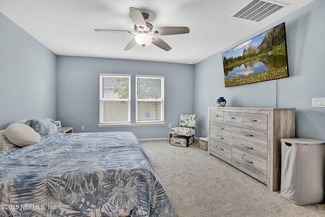 carpeted bedroom with a ceiling fan, a textured ceiling, and visible vents