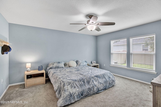 carpeted bedroom featuring a ceiling fan, baseboards, and a textured ceiling
