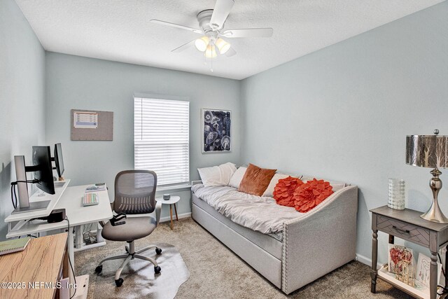 carpeted office with baseboards, a textured ceiling, and ceiling fan