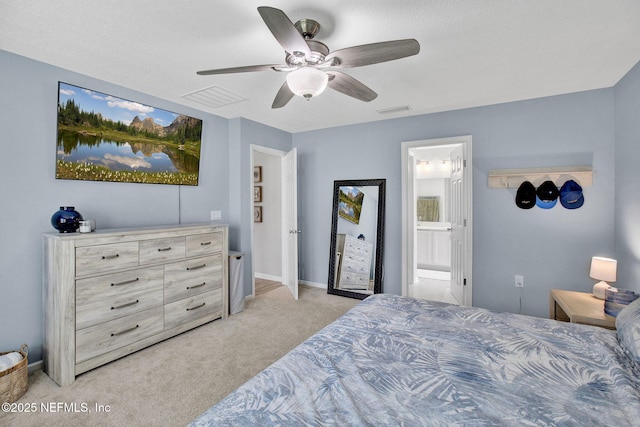 bedroom featuring a ceiling fan, visible vents, light carpet, and ensuite bath