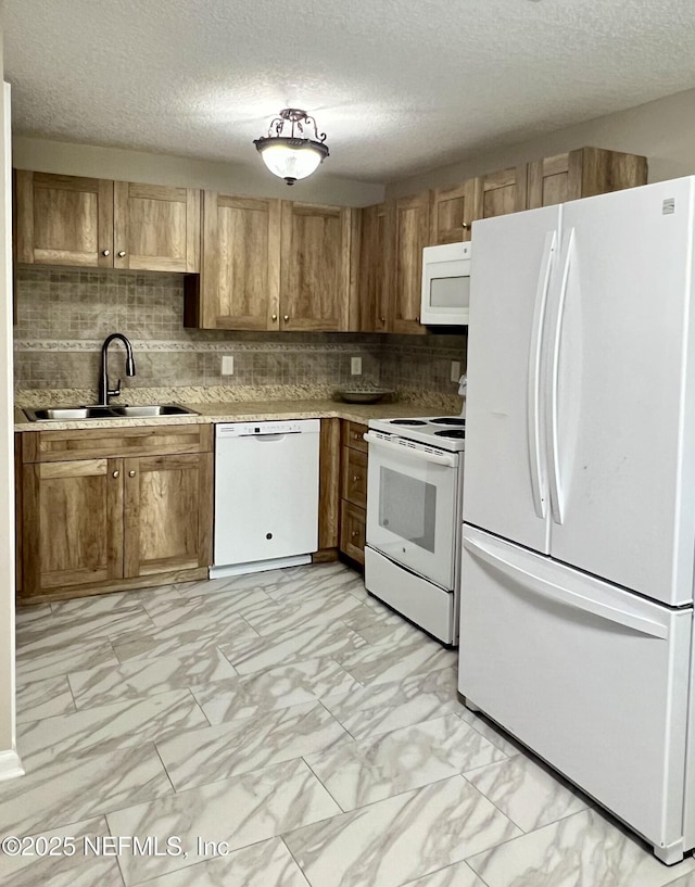 kitchen with tasteful backsplash, a sink, light countertops, marble finish floor, and white appliances