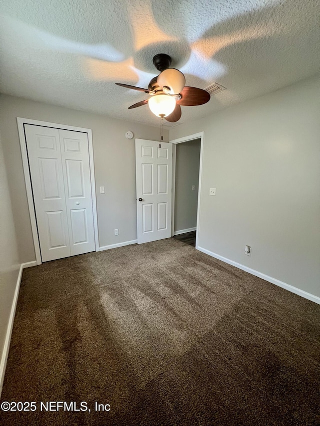 unfurnished bedroom featuring a closet, baseboards, carpet flooring, and a textured ceiling