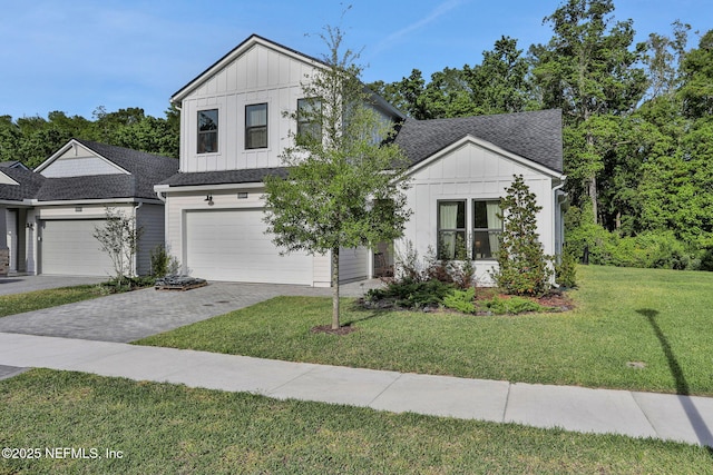 view of front of home with a shingled roof, board and batten siding, a front lawn, and driveway