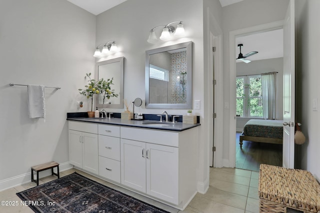 ensuite bathroom featuring baseboards, tile patterned floors, ensuite bathroom, and a sink