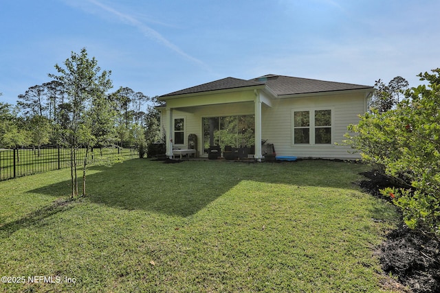 back of property with a yard, a fenced backyard, and roof with shingles