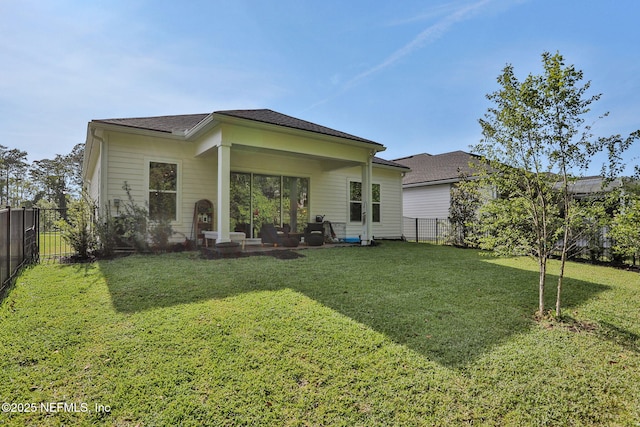 rear view of house featuring a yard, a patio area, and a fenced backyard
