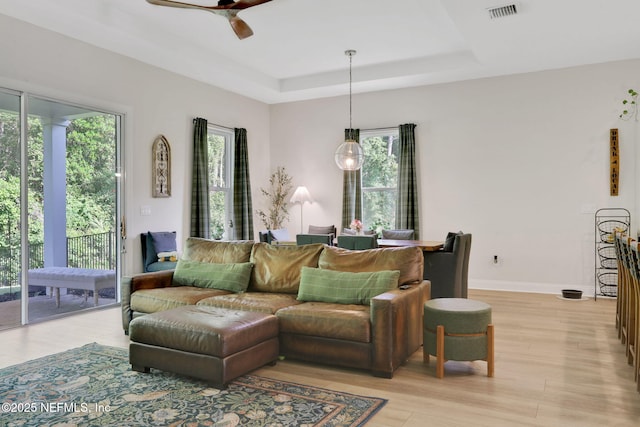 living area featuring visible vents, light wood finished floors, and plenty of natural light
