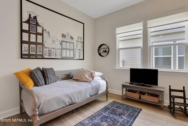 bedroom with wood finished floors and baseboards