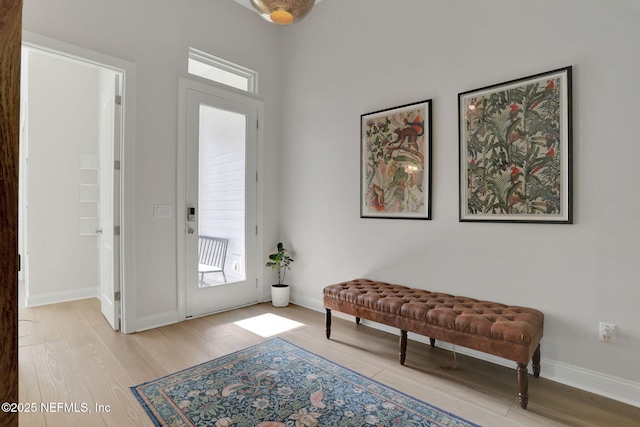 foyer entrance featuring baseboards and light wood-style floors