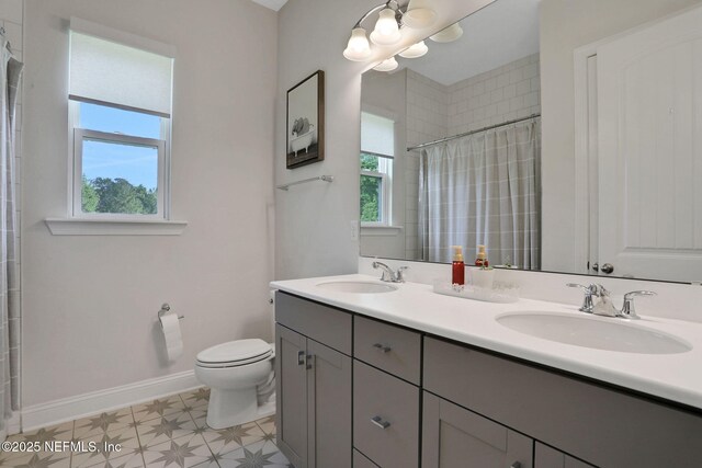 bathroom with double vanity, toilet, a shower with shower curtain, and a sink