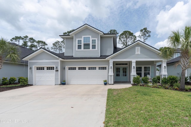 craftsman-style house featuring french doors, a front yard, concrete driveway, and an attached garage