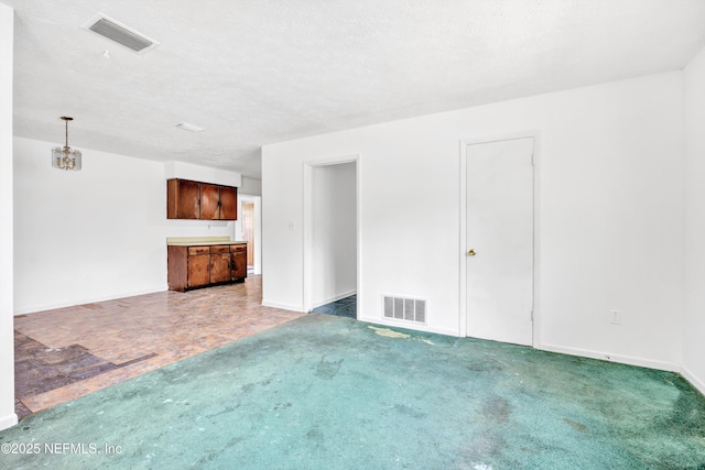 unfurnished living room featuring visible vents, baseboards, and carpet floors
