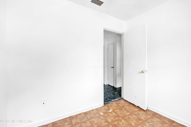 unfurnished room with baseboards and visible vents