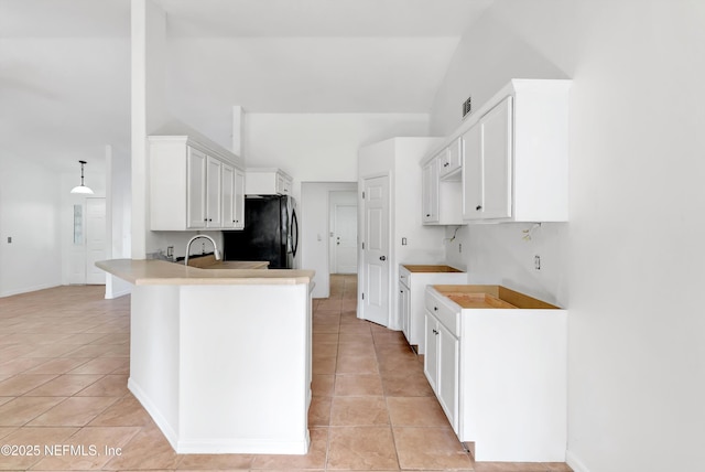 5329 Ogilvie Ln, Saint Augustine, FL 32086 - kitchen with light tile patterned floors, freestanding refrigerator, a peninsula, and lofted ceiling