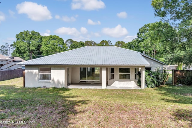 5329 Ogilvie Ln, Saint Augustine, FL 32086 - back of house featuring metal roof, a patio area, fence, a yard, and stucco siding