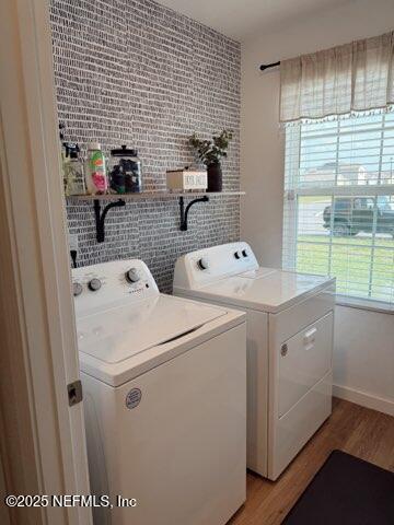laundry room with separate washer and dryer, laundry area, and light wood-style flooring