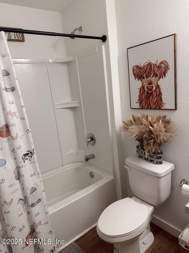 bathroom featuring toilet, shower / bath combination with curtain, wood finished floors, and baseboards