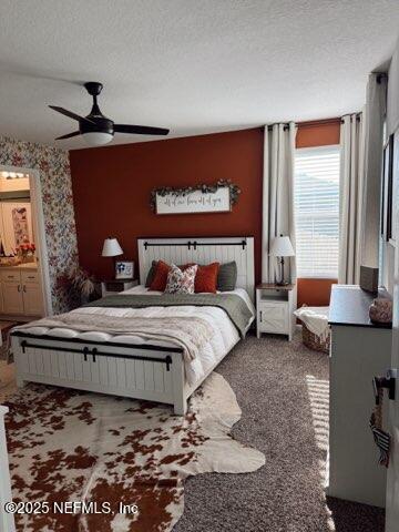 bedroom featuring a textured ceiling, ceiling fan, wallpapered walls, and carpet floors