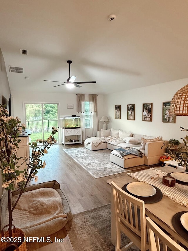 living area with visible vents, wood finished floors, and a ceiling fan