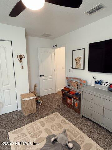 bedroom featuring visible vents, ceiling fan, and carpet