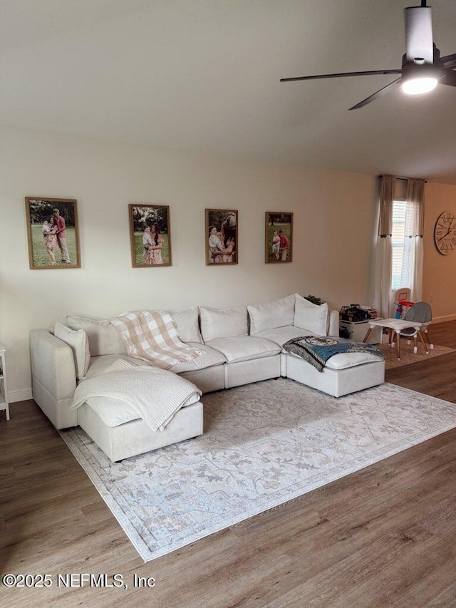 living room featuring a ceiling fan, wood finished floors, and baseboards