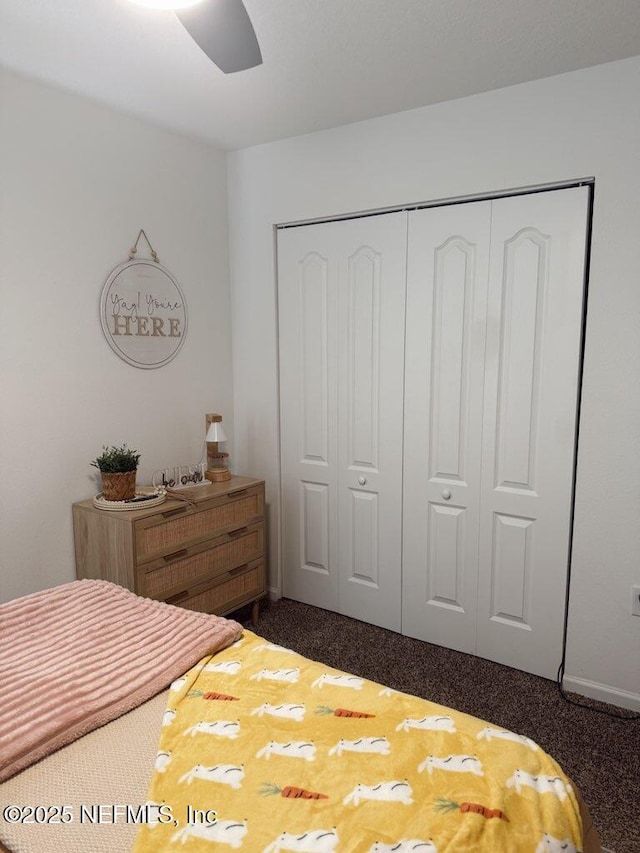 bedroom with dark carpet, a ceiling fan, and a closet