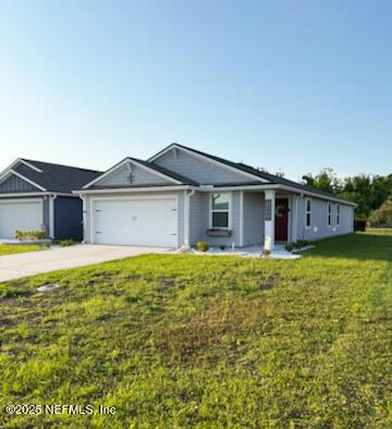 ranch-style home with a garage, a front yard, and concrete driveway