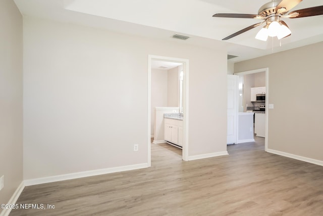 empty room featuring visible vents, ceiling fan, baseboards, and light wood-style floors