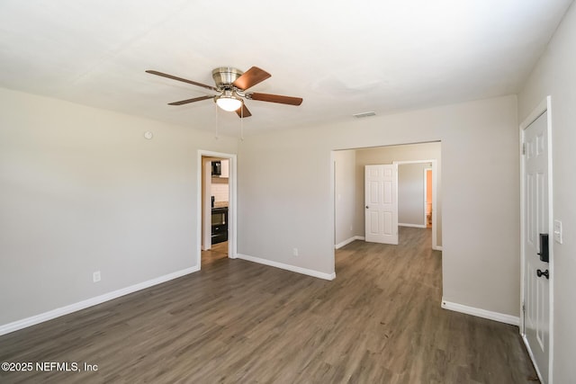 unfurnished bedroom featuring dark wood finished floors, baseboards, visible vents, and a ceiling fan