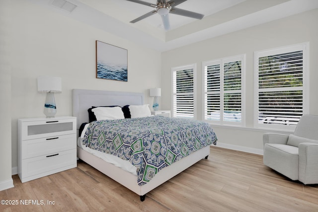 bedroom featuring baseboards, visible vents, ceiling fan, and light wood-style floors