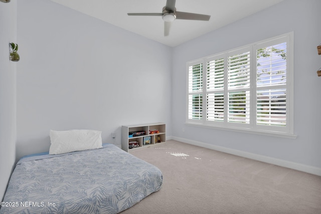 carpeted bedroom featuring baseboards and ceiling fan