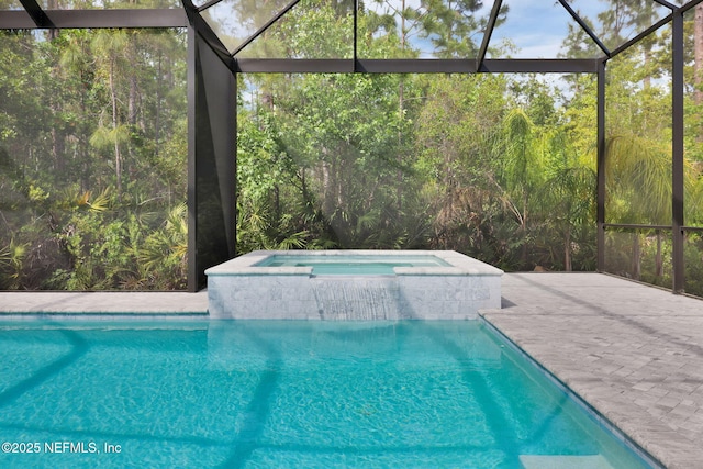 view of pool featuring a wooded view, a pool with connected hot tub, a lanai, and a patio area