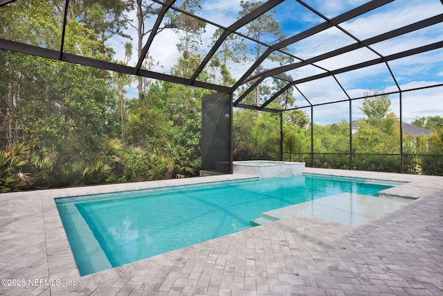 view of swimming pool with glass enclosure, a patio, and a pool with connected hot tub