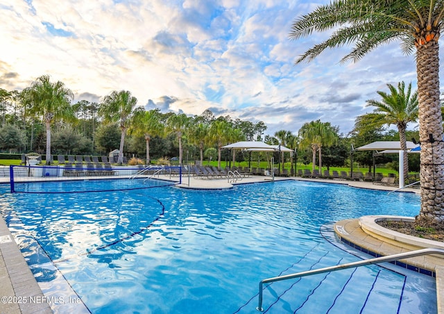 community pool with a patio area and fence