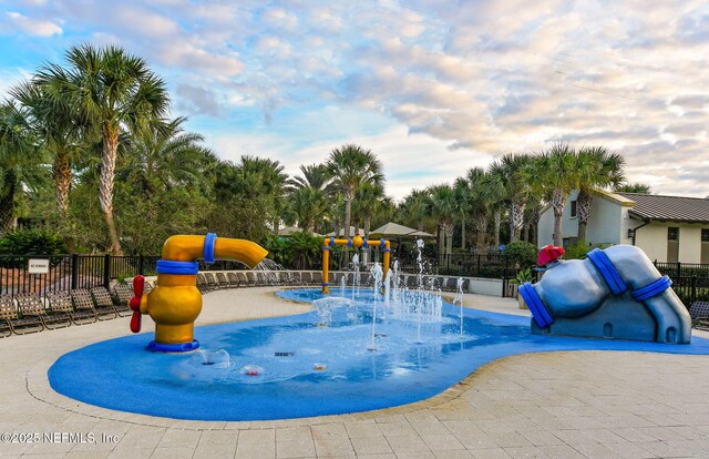 view of playground featuring fence and a water play area