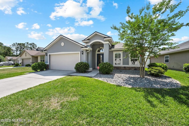 ranch-style home with a front lawn, concrete driveway, an attached garage, stone siding, and stucco siding