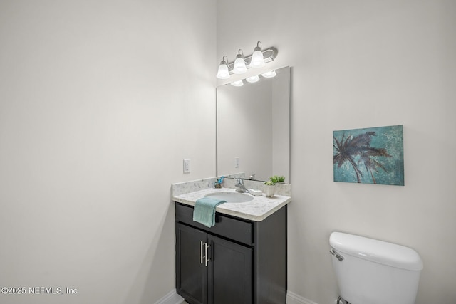bathroom featuring vanity, baseboards, and toilet