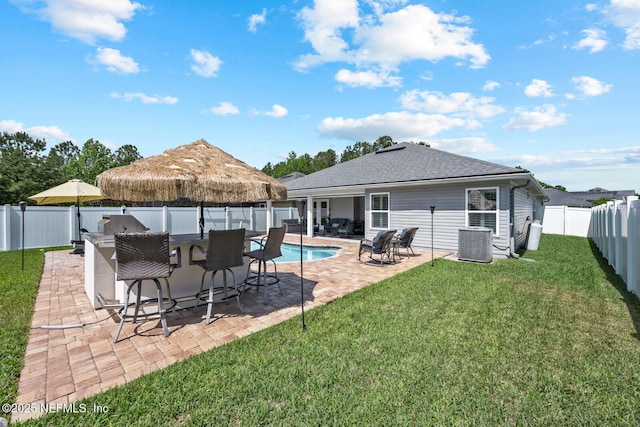 rear view of house featuring a lawn, central AC unit, outdoor dry bar, a fenced backyard, and a shingled roof