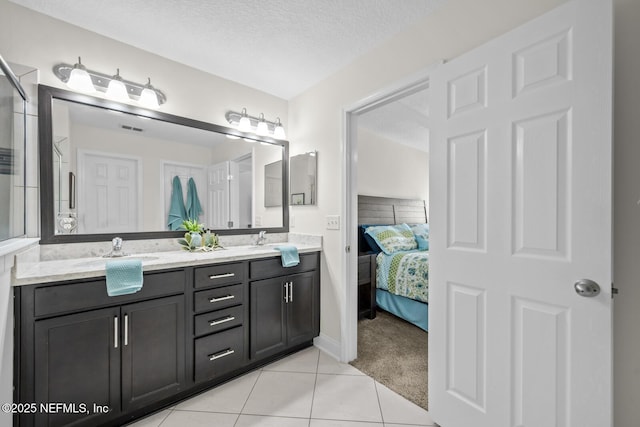 ensuite bathroom with tile patterned flooring, visible vents, double vanity, connected bathroom, and a sink